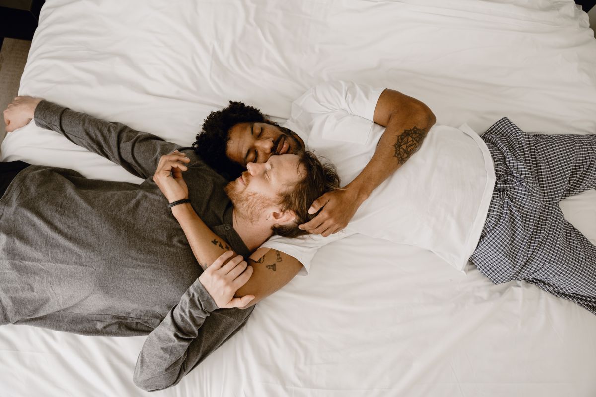two men lie in an embrace
